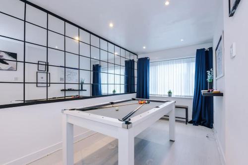 a pool table in a room with blue curtains at Sleeps 7, Games Room, Perfect For Groups, Driveway, Smart TV, Available For Long Stays in Manchester