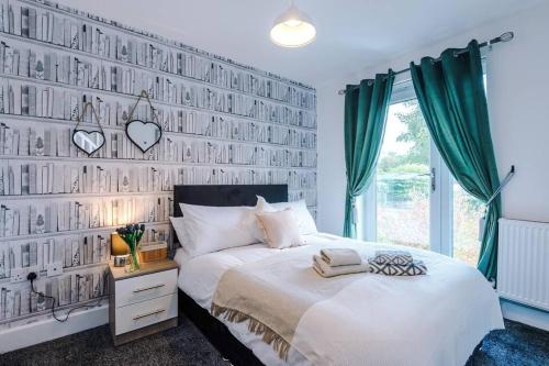 a bedroom with a bed and a wall of photos at Sleeps 7, Games Room, Perfect For Groups, Driveway, Smart TV, Available For Long Stays in Manchester