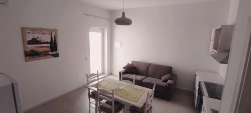 a living room with a couch and a table at Deluxe Family Suite in San Menaio