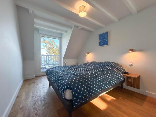 une chambre avec un lit dans une pièce avec une fenêtre dans l'établissement Mazi Bihan, à Combrit