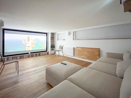 un salon avec un canapé et une télévision à écran plat dans l'établissement Mazi Bihan, à Combrit