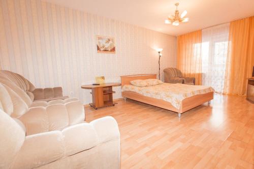 トムスクにあるKvartira on Lenina 166のベッドルーム1室(ベッド1台、ソファ、テーブル付)