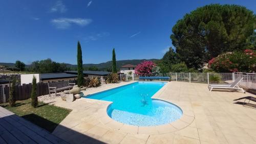 une piscine dans une cour avec un patio dans l'établissement Terre de Crussol - Gite 3 étoiles en Ardèche, avec piscine et clim, 2-4 personnes, à Saint-Péray