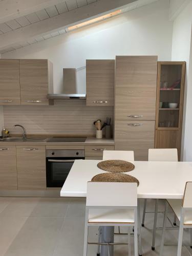 a kitchen with white tables and white chairs at Oasi del Po in Monticelli dʼOngina