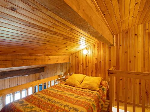 a bedroom with a bed in a wooden room at Appartement face au lac 6 voyageurs in Les Angles