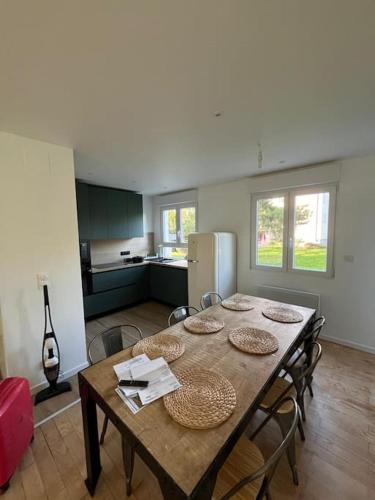 une cuisine avec une table en bois avec des chaises et une tableasteryasteryasteryasteryasteryastery dans l'établissement Olivier du ciel ODC, à Strasbourg