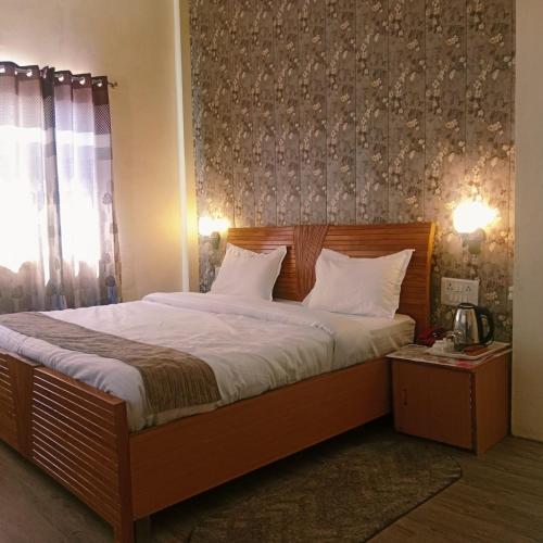 a bedroom with a large bed with white pillows at Burans Breeze in Dhanaulti