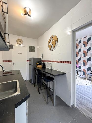 - une cuisine avec une table noire et un évier dans l'établissement Cosynist, à Choisy-le-Roi