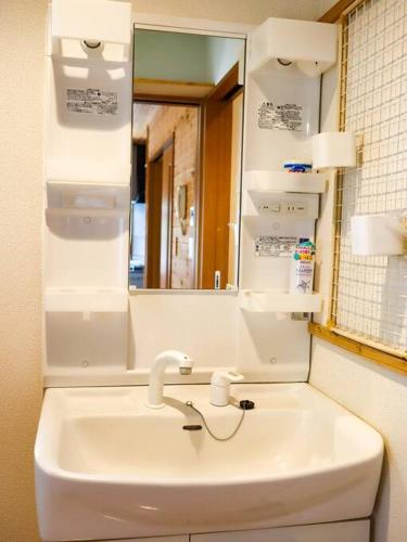 a bathroom with a sink and a mirror at Atami Costa resort with Onsen in Nakano