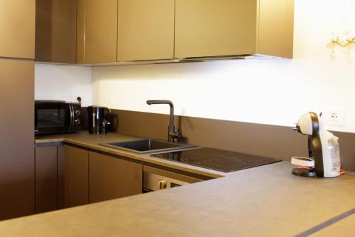 a kitchen with a sink and a microwave at SKYWAY LOFT - Agenzia Dolomiti Affitti in Cavalese