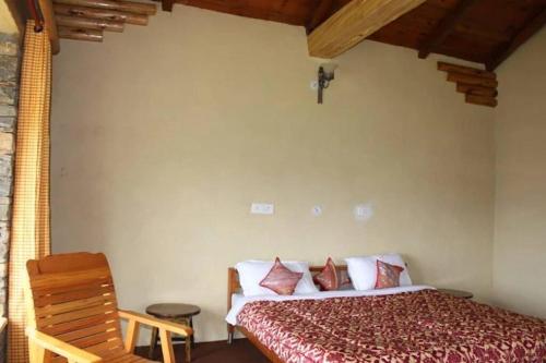 a bedroom with a bed and a wooden chair at Breezy Affair -Binsar View Boutique Room in Binsar