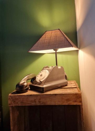 a desk with a phone and a lamp on it at La Maison des Oiseaux in Crouzilles