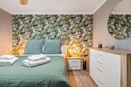 a bedroom with a green bed with a leafy wallpaper at Villa Pedreiro in Funchal