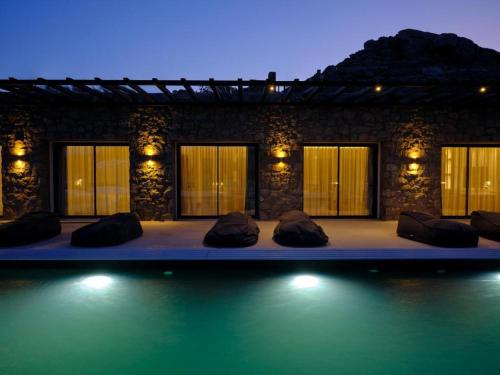 a swimming pool with pillows in front of a building at Villa Christy in Psarou