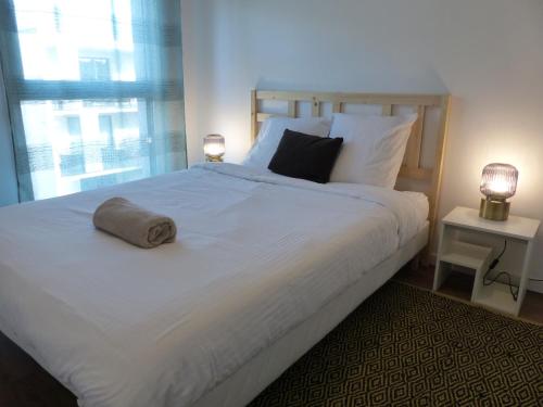 une chambre avec un grand lit blanc avec deux lampes dans l'établissement Appartement Saint Maurice avec parking, à Lille