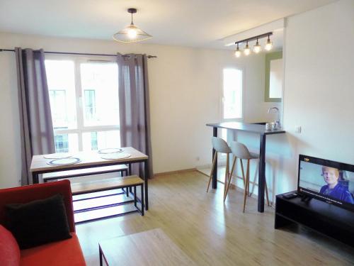 un salon avec une table à manger et une télévision dans l'établissement Appartement Saint Maurice avec parking, à Lille