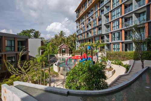 a playground in front of a apartment building at Apartment in Mida Grande Surin in Ban Lum Fuang