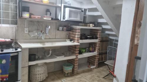 a kitchen with a sink and a microwave at Casa Margarida in Brasília