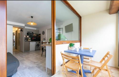 une salle à manger et une cuisine avec une table bleue et des chaises dans l'établissement Appartement T2 Hyper Centre RoLéo, à Saint-Lary-Soulan