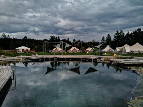 a large pool of water with a group of tents at Gerhardhof - Zimmer Glamping Camping in Wildermieming