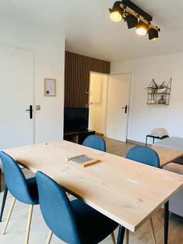 une salle de conférence avec une table en bois et des chaises bleues dans l'établissement Superbe Appartement Poissy proche Gare / Stellantis, à Poissy