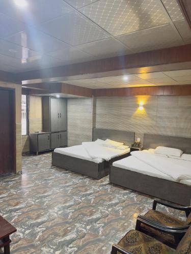 a large room with two beds in it at But Hotel & Tourist Inn in Murree