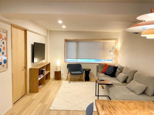 a living room with a couch and a chair at Den Nozawa in Nozawa Onsen