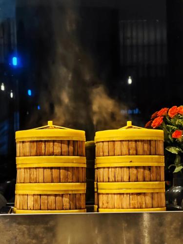 two stacks of wooden barrels on a counter with flowers at Arthur Hotel Zhujiang New Town Guangzhou-Free Shuttle Bus to Exhibition Centre during Canton Fair in Guangzhou