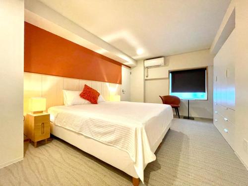 a bedroom with a large bed and a flat screen tv at Den Nozawa in Nozawa Onsen