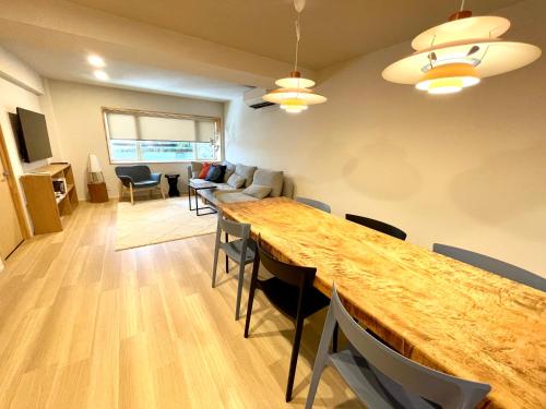 a living room with a large wooden table and chairs at Den Nozawa in Nozawa Onsen