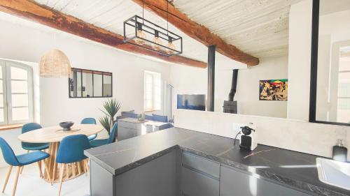 une cuisine avec une table et des chaises bleues dans l'établissement La Calade-Maison Centre Historique, à Pertuis