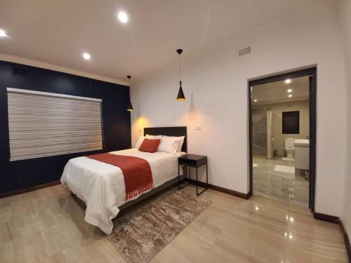 a bedroom with a large bed and a bathroom at Comfortable and luxurious stay in Gweru