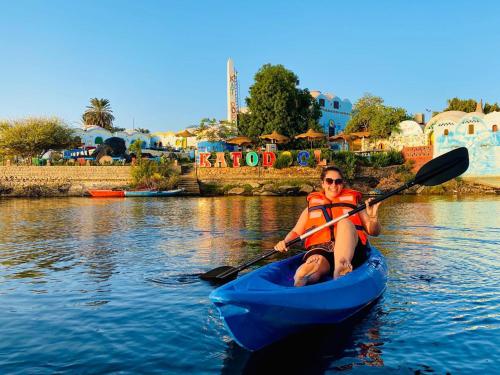 a man in a blue kayak on the water at Dolty Kato Nubian House By Kato Dool in Aswan