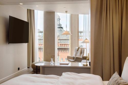 a hotel room with a bed and a desk and a window at Solo Sokos Hotel Pier 4 in Helsinki