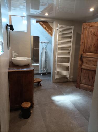 La salle de bains est pourvue d'un lavabo et d'une porte en bois. dans l'établissement Chez Marie et Fred, à Hoffen