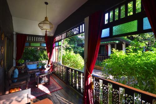 a balcony of a house with a view of the garden at Thai Thai Sukhothai Resort in Sukhothai
