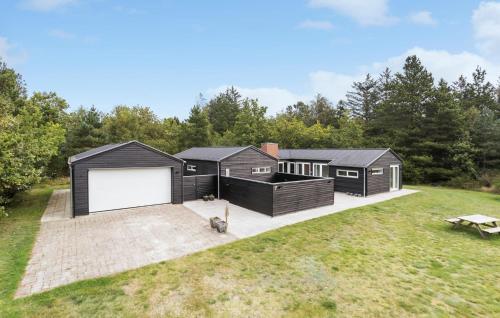 a black tiny house with a large white garage at 4 Bedroom Cozy Home In Ålbæk in Ålbæk