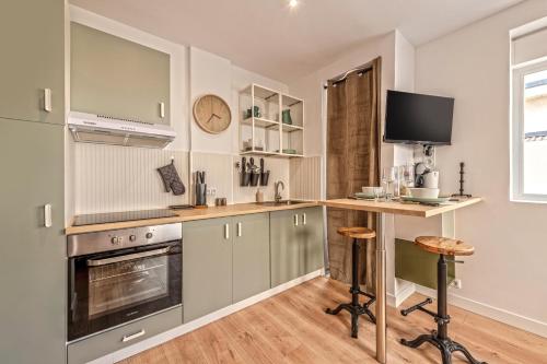 une cuisine avec des armoires vertes et un comptoir avec un bureau dans l'établissement Le Botanique ~ Proche Centre ~ Arrivée Autonome, à Brest