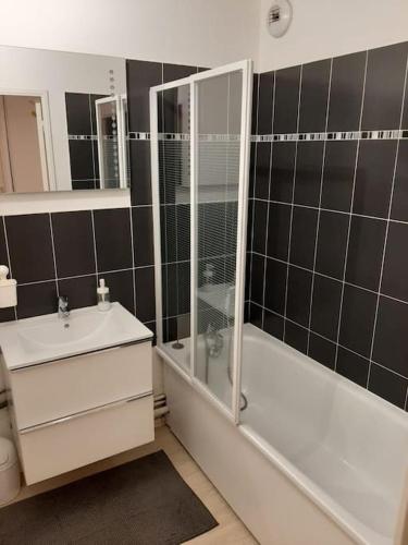 a bathroom with a shower and a tub and a sink at Joli appartement avec Jardin et 2 parkings privés in Argenteuil