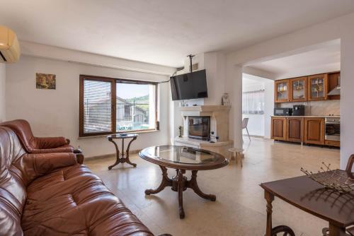 a living room with a couch and a table at Villa Sineva - Pool, BBQ & Seaview in Fish Fish