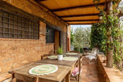 an outdoor patio with a wooden table and chairs at Greg's House in Santa Lucia