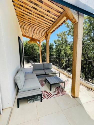 a patio with chairs and a table and a wooden pergola at Villa Carpe Diem - Clim & Vue lac in Bauduen