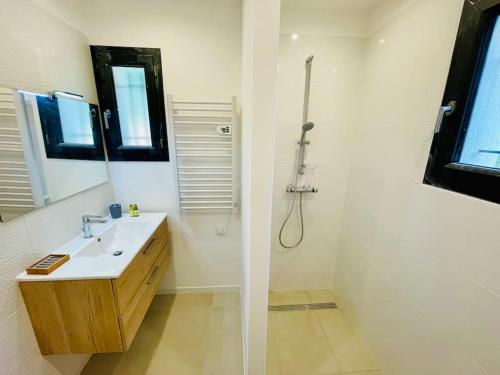 a white bathroom with a sink and a shower at Villa Carpe Diem - Clim & Vue lac in Bauduen