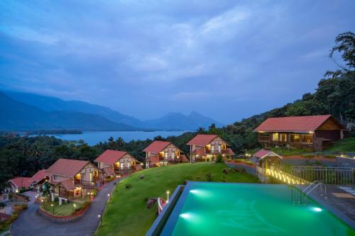 an aerial view of a resort with a lake and mountains at Au Revoir Wellness Resort, Malampuzha in Palakkad