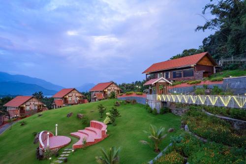 a group of chairs on a lawn in front of a house at Au Revoir Wellness Resort, Malampuzha in Palakkad