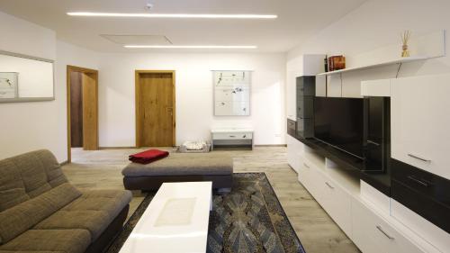 Feistritz ob BleiburgにあるHaus am Fischteichのリビングルーム(ソファ、大画面テレビ付)