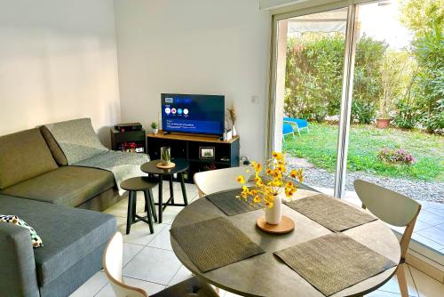 un salon avec un canapé et une table dans l'établissement Beachside Apartment with Pool & Garden in Juan les Pins, à Antibes