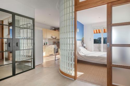 een keuken met glazen deuren en een slaapkamer bij Appart vue mer pour 4 à St Brevin les Pins in Saint-Brevin-les-Pins