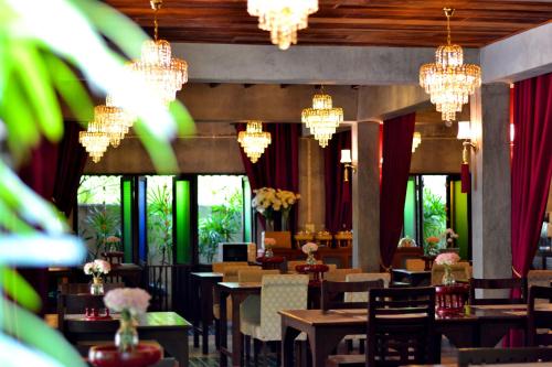 a dining room with chandeliers and tables and chairs at Thai Thai Sukhothai Resort in Sukhothai