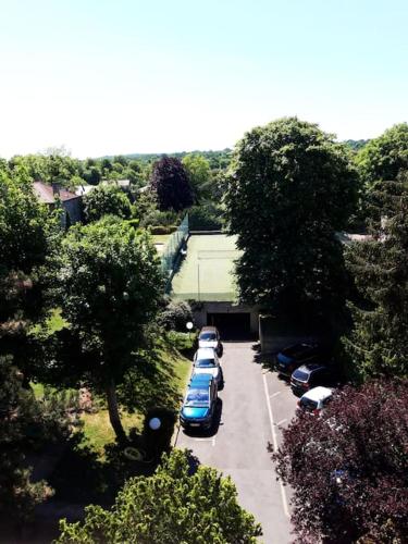 Une rangée de voitures garées sur un parking dans l'établissement Appartement avec jardin et Tennis, à Saint-Cloud